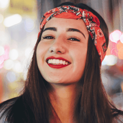 selective focus photography of smiling woman wearing red and black bandana