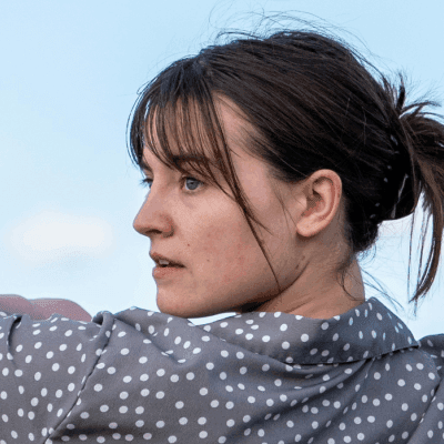 a woman is throwing a frisbee in a field