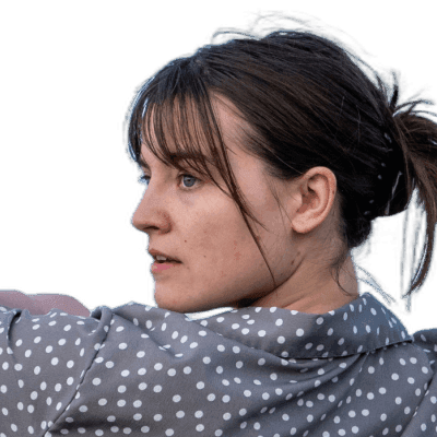 a woman is throwing a frisbee in a field