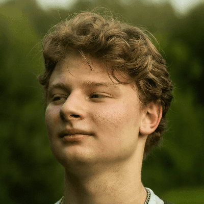 A young man with a backpack and a frisbee in his hand