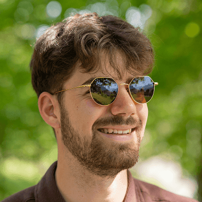 A man in a brown shirt and sunglasses