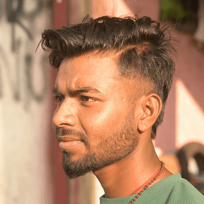 A man in a green shirt standing in front of a building