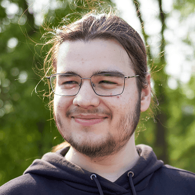 A smiling young man is looking at something.