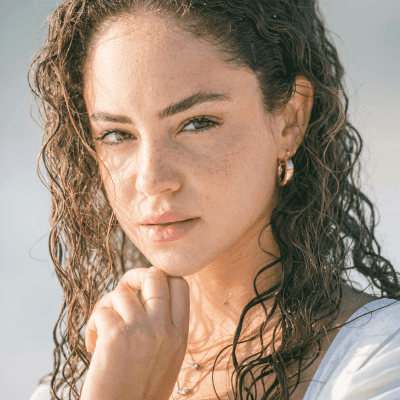 a woman with curly hair wearing a white dress