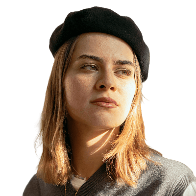 a woman wearing a black hat standing in front of a white wall