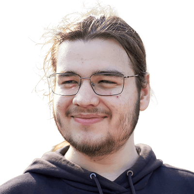 A smiling young man is looking at something.